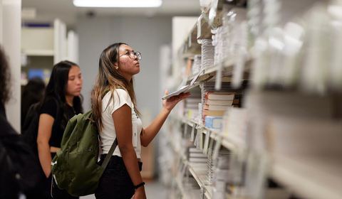 A student browsing a shelf